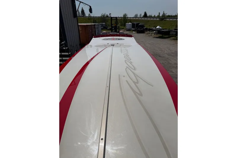 Slide: The Image of 2003 Cigarette 36' Gladiator boat with red and white design, parked outdoors. - 21