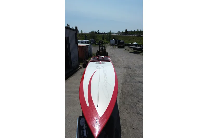 Slide: The Image of 2003 Cigarette 36' Gladiator boat with red and white design, parked outdoors. - 5