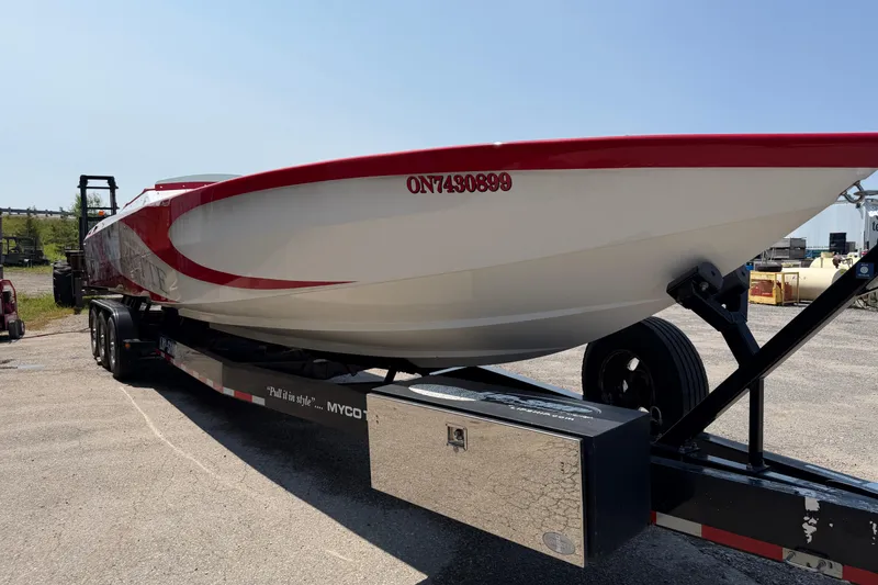 Slide: The Image of 2003 Cigarette 36' Gladiator boat on trailer, featuring red and white design. - 7