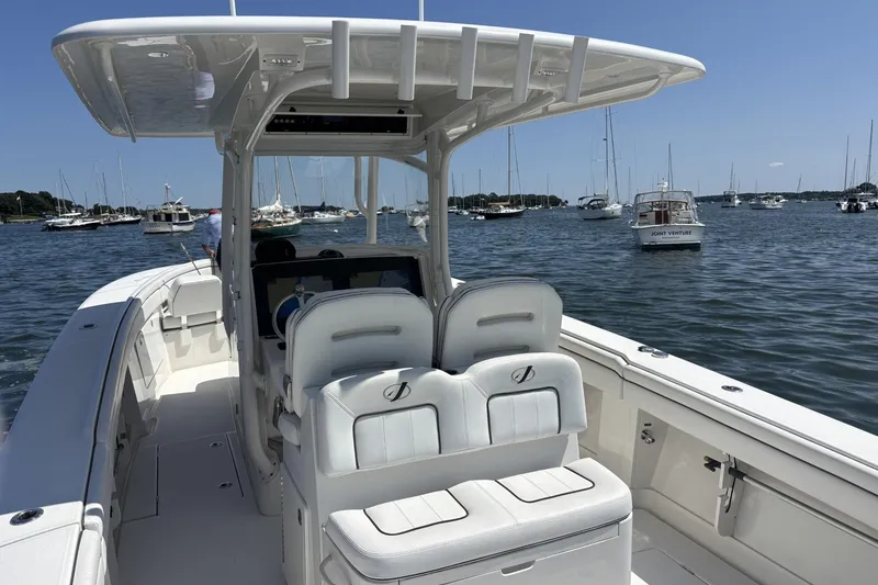 Slide: The Image of 2018 Jupiter 34 boat on water, surrounded by other boats under clear blue sky. - 5