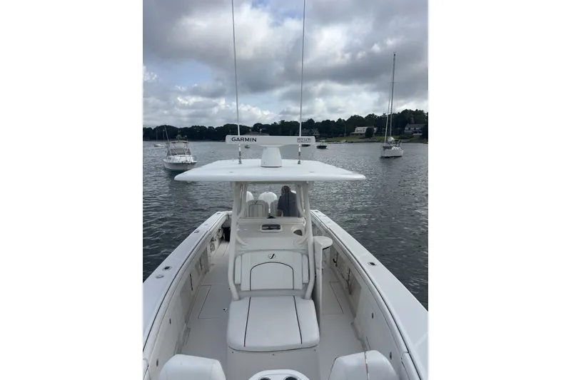 Slide: The Image of 2018 Jupiter 34 boat on calm water with overcast sky and nearby sailboats. - 15
