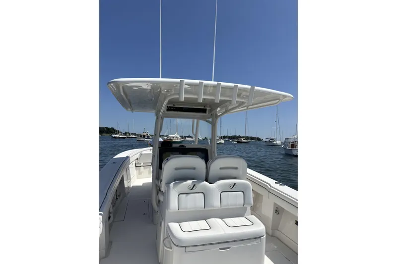 Slide: The Image of 2018 Jupiter 34 boat interior with seating, docked in a marina under clear blue sky. - 12