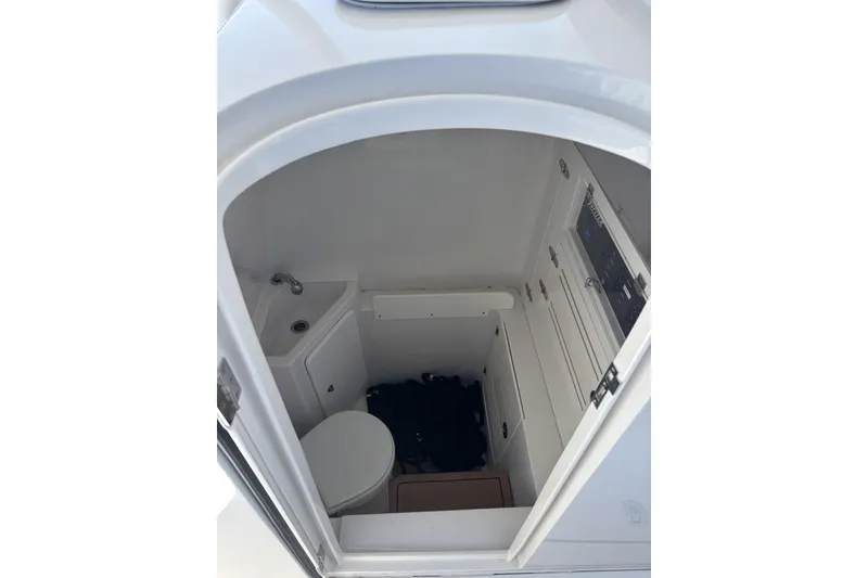 Slide: The Image of 2018 Jupiter 34 boat interior with compact bathroom, featuring a toilet and sink. - 14