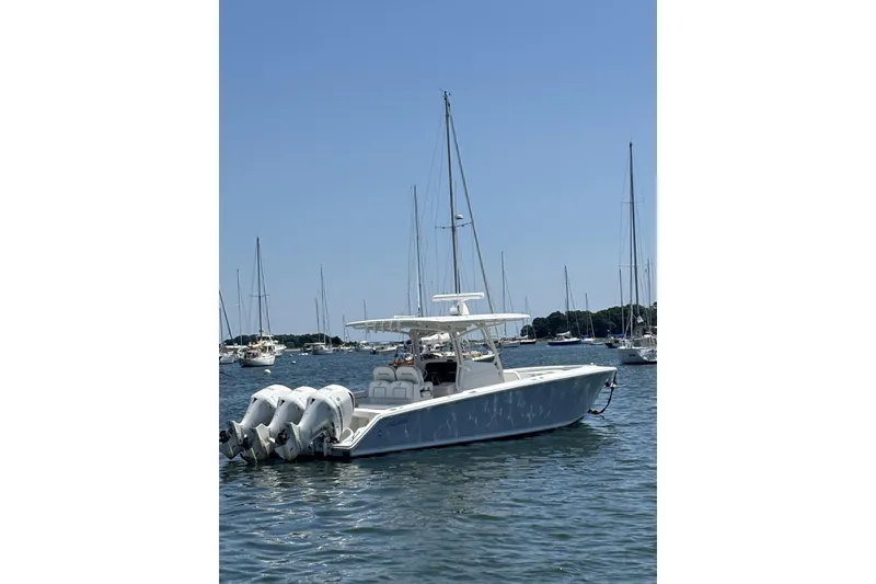 Slide: The Image of 2018 Jupiter 34 boat with triple engines on calm water, surrounded by sailboats. - 1