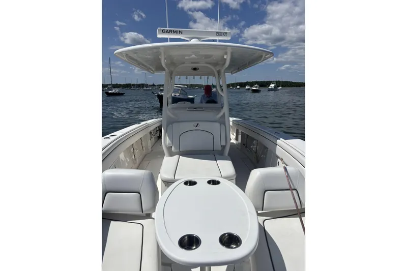 Slide: The Image of 2018 Jupiter 34 boat with seating and table, docked on a sunny day. - 8