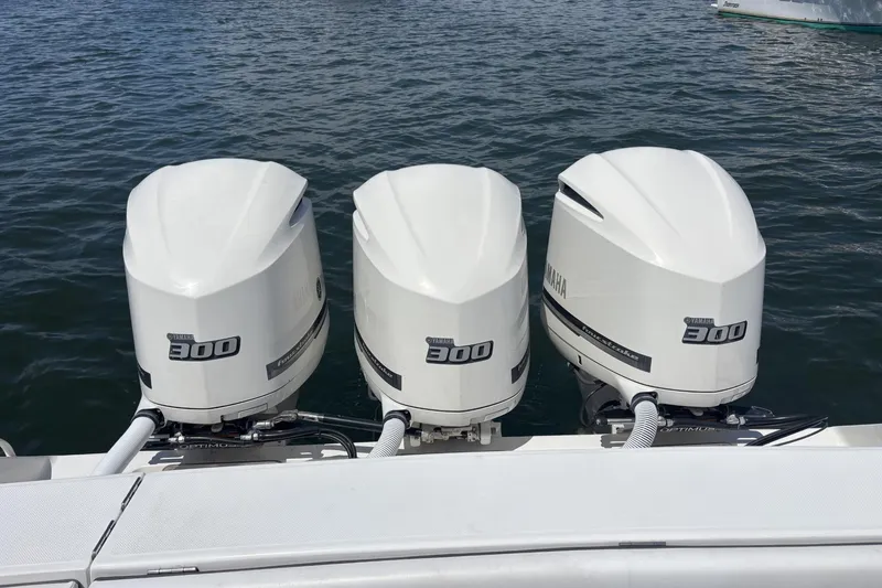 Slide: The Image of Triple Yamaha 300 outboard engines on a 2018 Jupiter 34 boat, docked on water. - 13