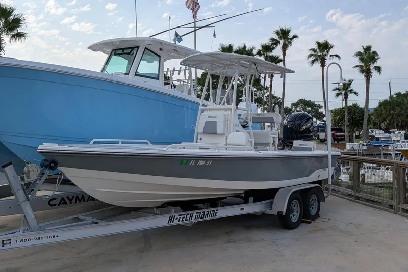 The Image of 2021 Pathfinder 2200 TRS boat on trailer at marina with palm trees. - 1