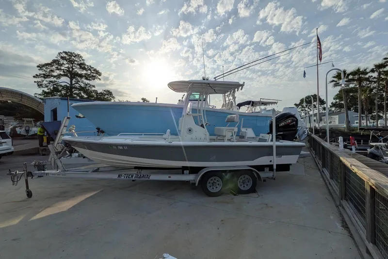 Slide: The Image of 2021 Pathfinder 2200 TRS boat on trailer at marina, under a partly cloudy sky. - 3