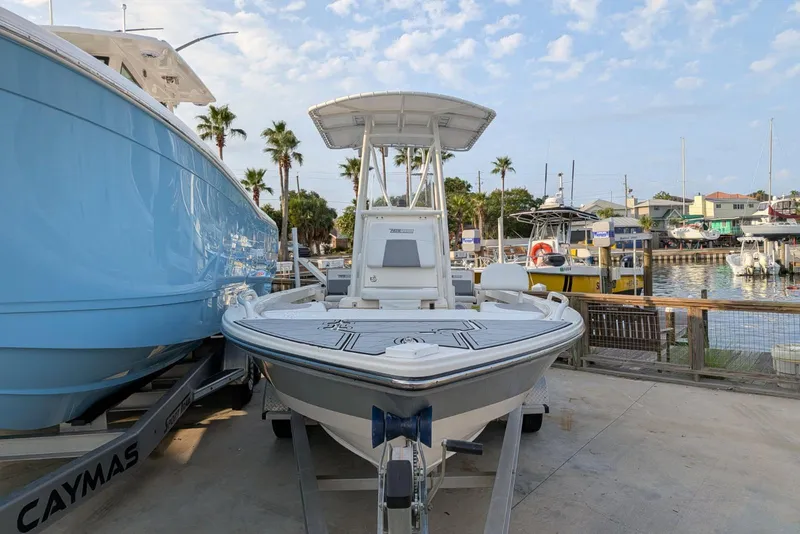 Slide: The Image of 2021 Pathfinder 2200 TRS boat docked at a marina with palm trees and blue sky. - 4