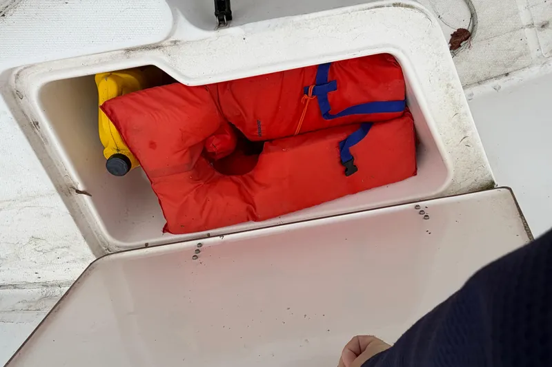 Slide: The Image of Storage compartment on 2006 Seahunt 207 Triton boat with life jackets and safety gear. - 10