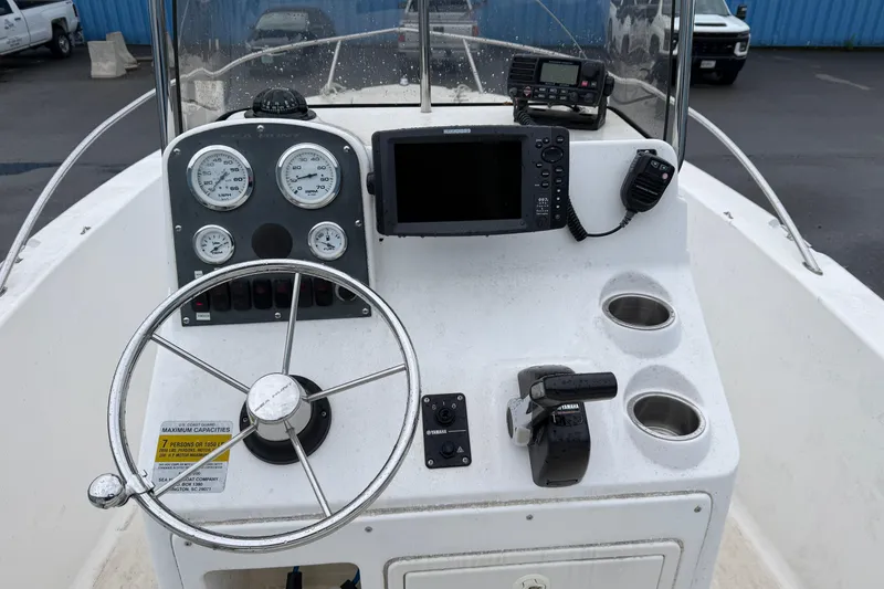 Slide: The Image of Console of a 2006 Seahunt 207 Triton boat with steering wheel and gauges. - 2