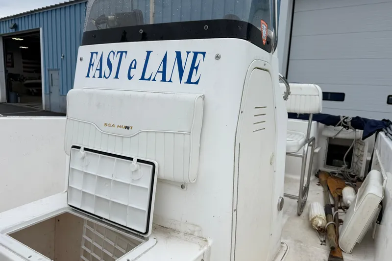 Slide: The Image of 2006 Seahunt 207 Triton boat with "FAST e LANE" text on console, docked near a blue building. - 13