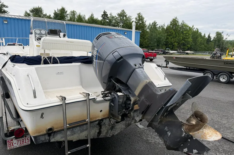 Slide: The Image of 2006 Seahunt 207 Triton boat with outboard motor in a parking lot. - 3