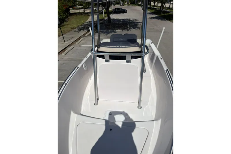 Slide: The Image of 2016 Pro-Line 20 Sport boat deck with T-top and seating, parked outdoors. - 21