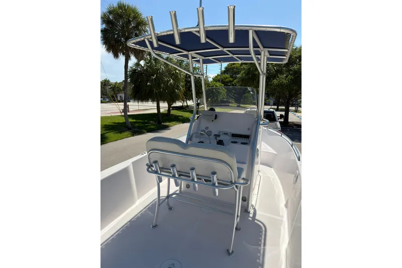 Slide: The Image of 2016 Pro-Line 20 Sport boat with T-top and helm station, parked near palm trees. - 10