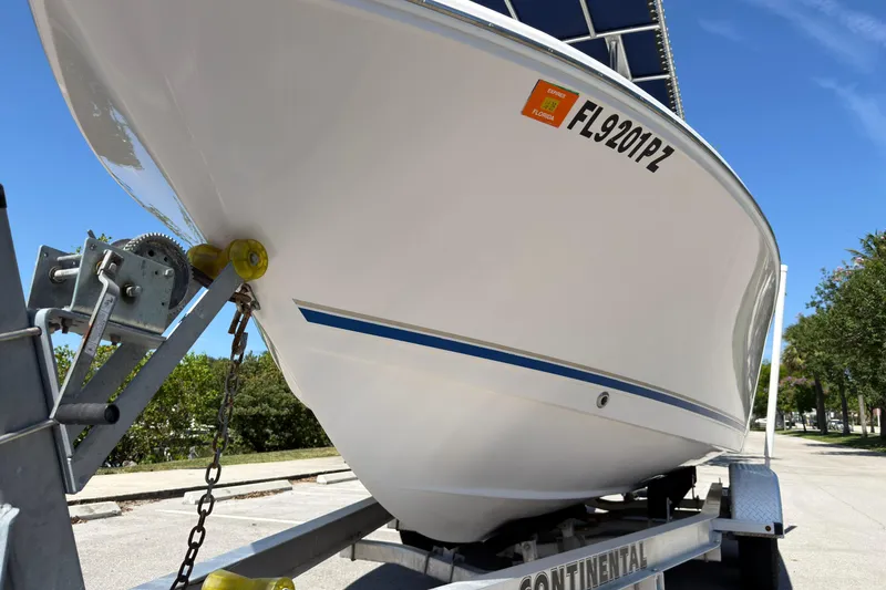 Slide: The Image of 2016 Pro-Line 20 Sport boat on trailer, parked outdoors under clear blue sky. - 8