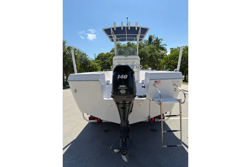 Slide: The Image of 2016 Pro-Line 20 Sport boat with outboard motor and ladder, parked on a sunny day. - 4