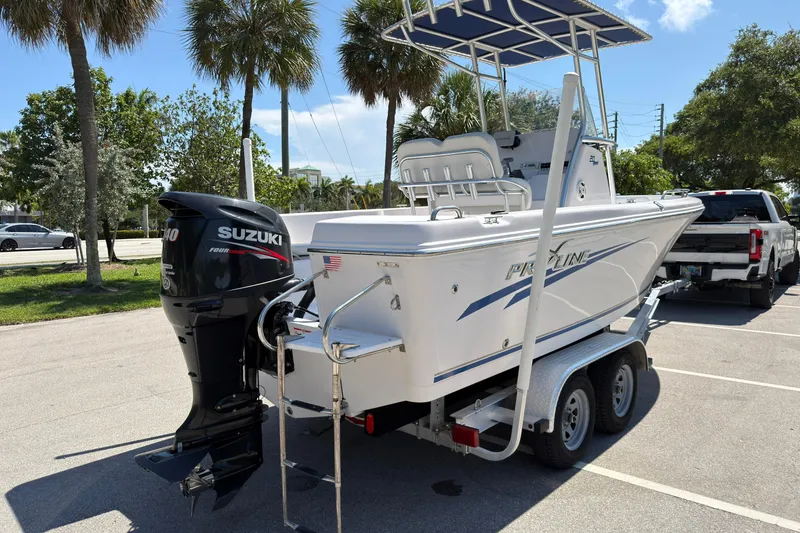Slide: The Image of 2016 Pro-Line 20 Sport boat on trailer with Suzuki outboard motor in sunny parking lot. - 3