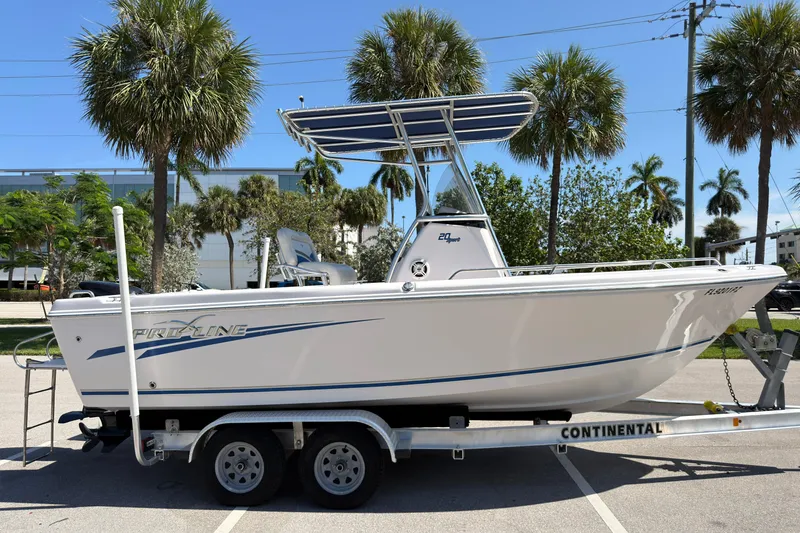 Slide: The Image of 2016 Pro-Line 20 Sport boat on trailer, surrounded by palm trees in a sunny setting. - 2