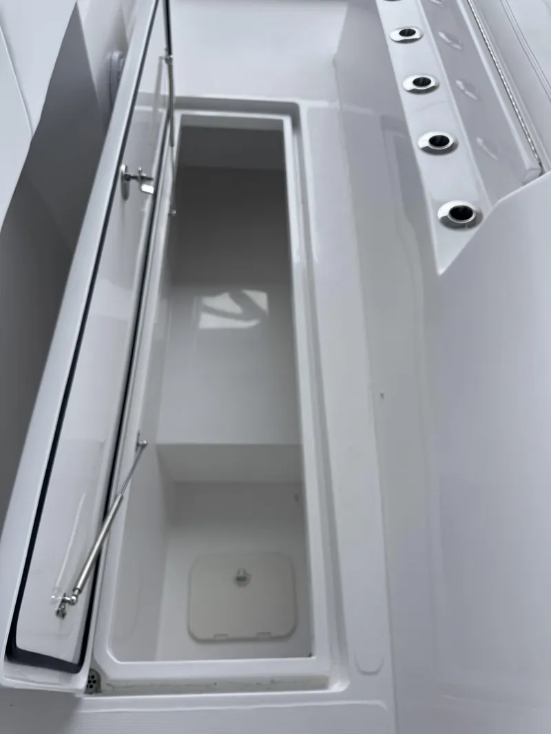 Slide: The Image of An open storage compartment on a modern boat with several cup holders beside it. - 12