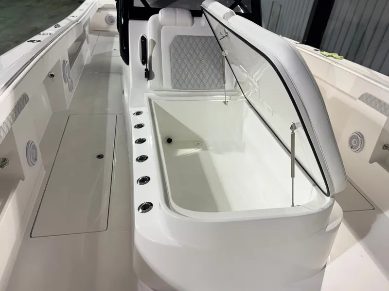 Slide: The Image of The image shows the deck of a 2027 Front Runner Boatworks 37 Cat with an open storage compartment. - 27