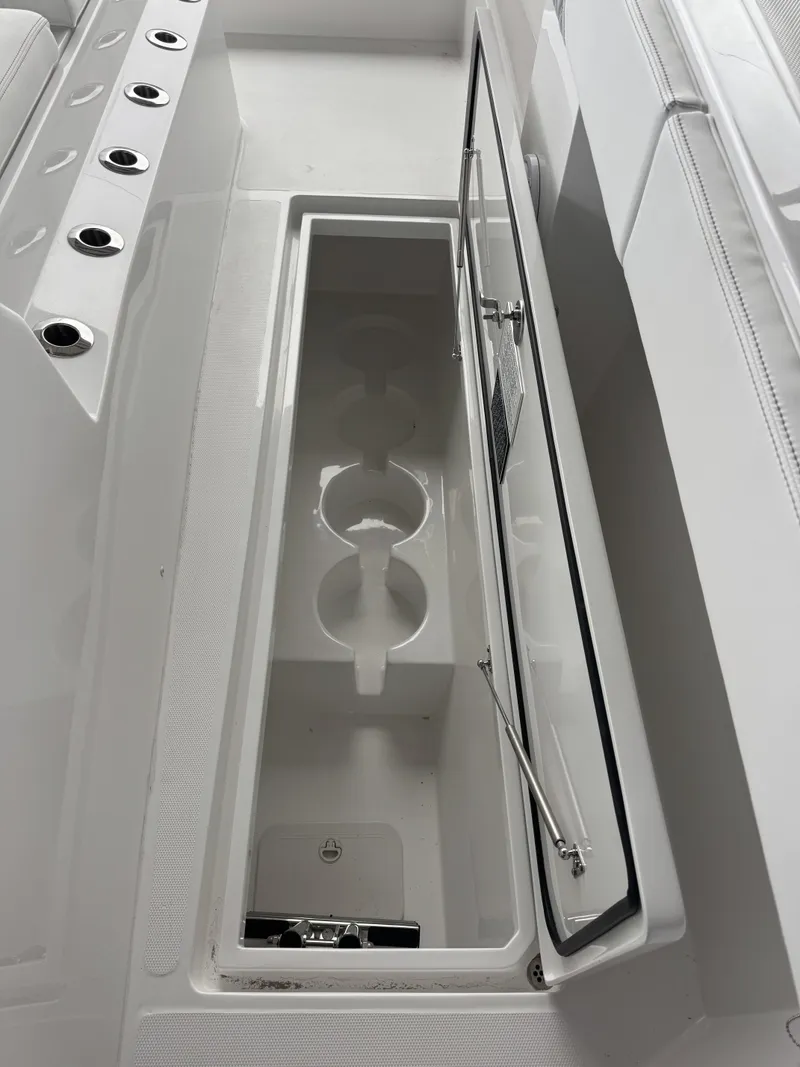 Slide: The Image of An open storage compartment on a boat with cup holders and a lid. - 13