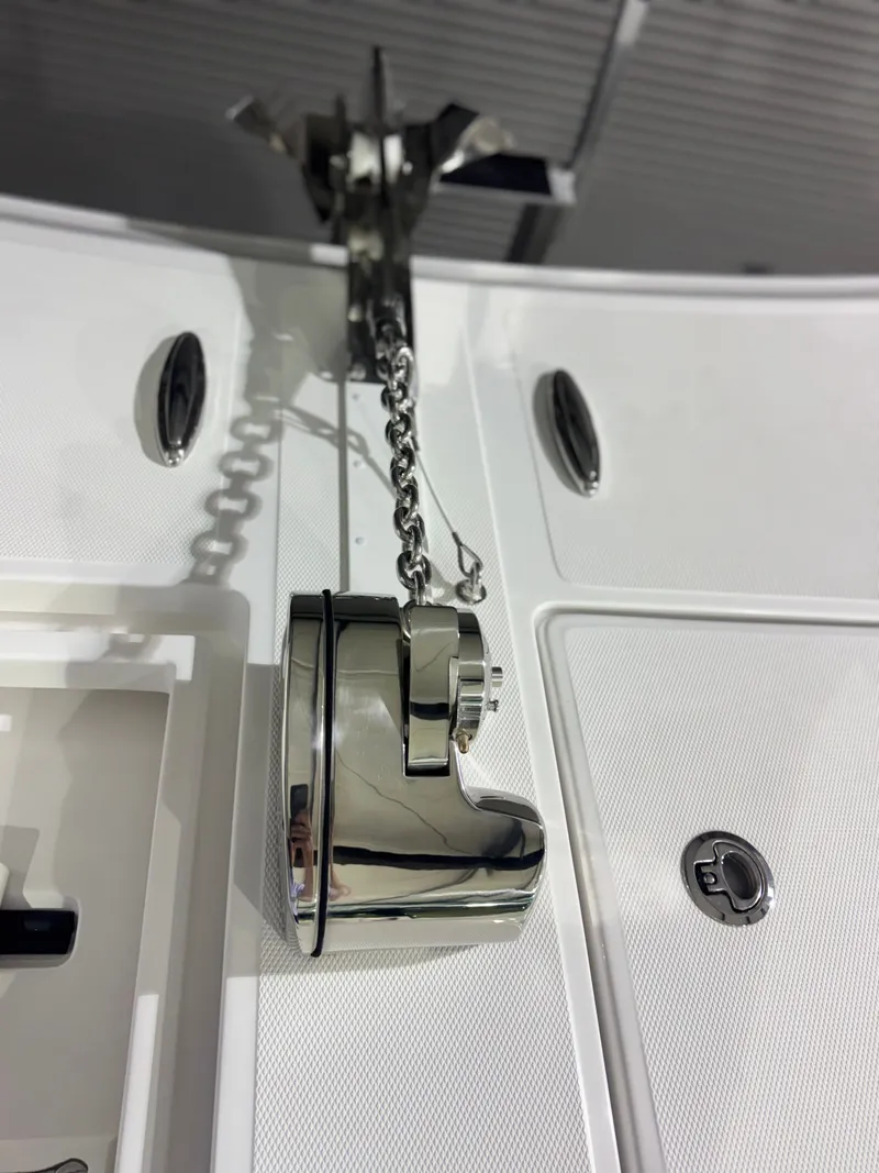 Slide: The Image of Close-up of a shiny anchor system on a modern boat, featuring chain and polished metal components. - 26