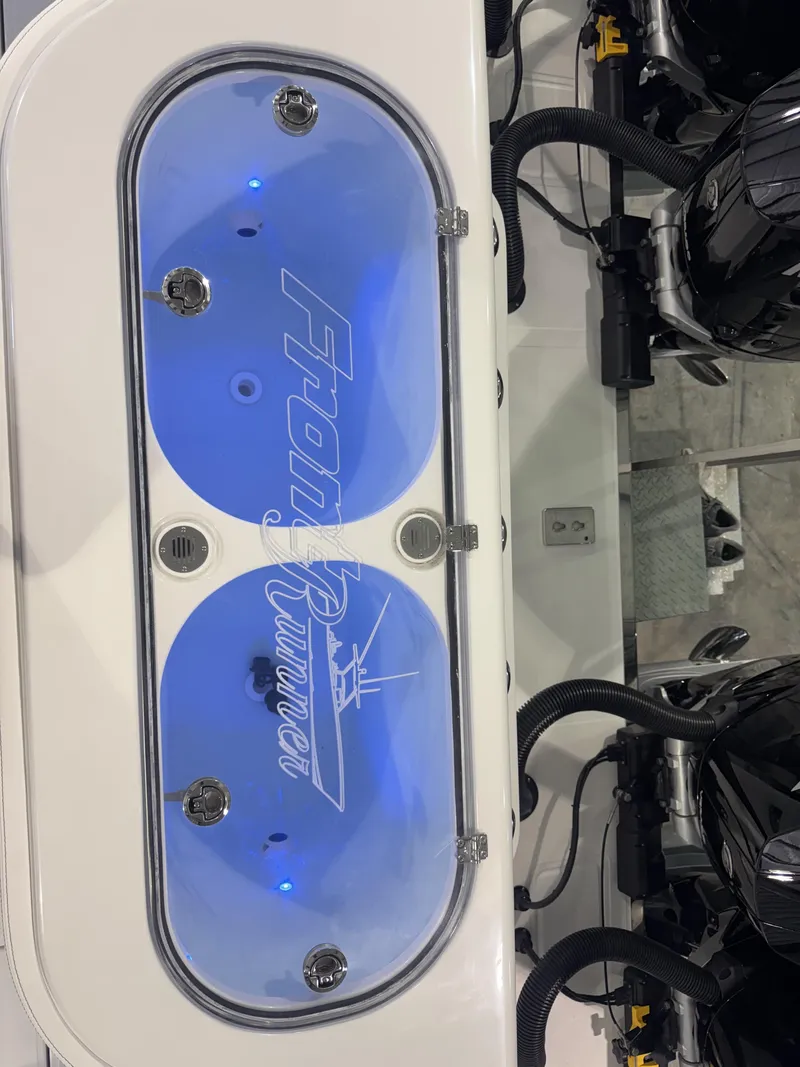 Slide: The Image of A modern boat with a lit blue livewell and two engines. - 6