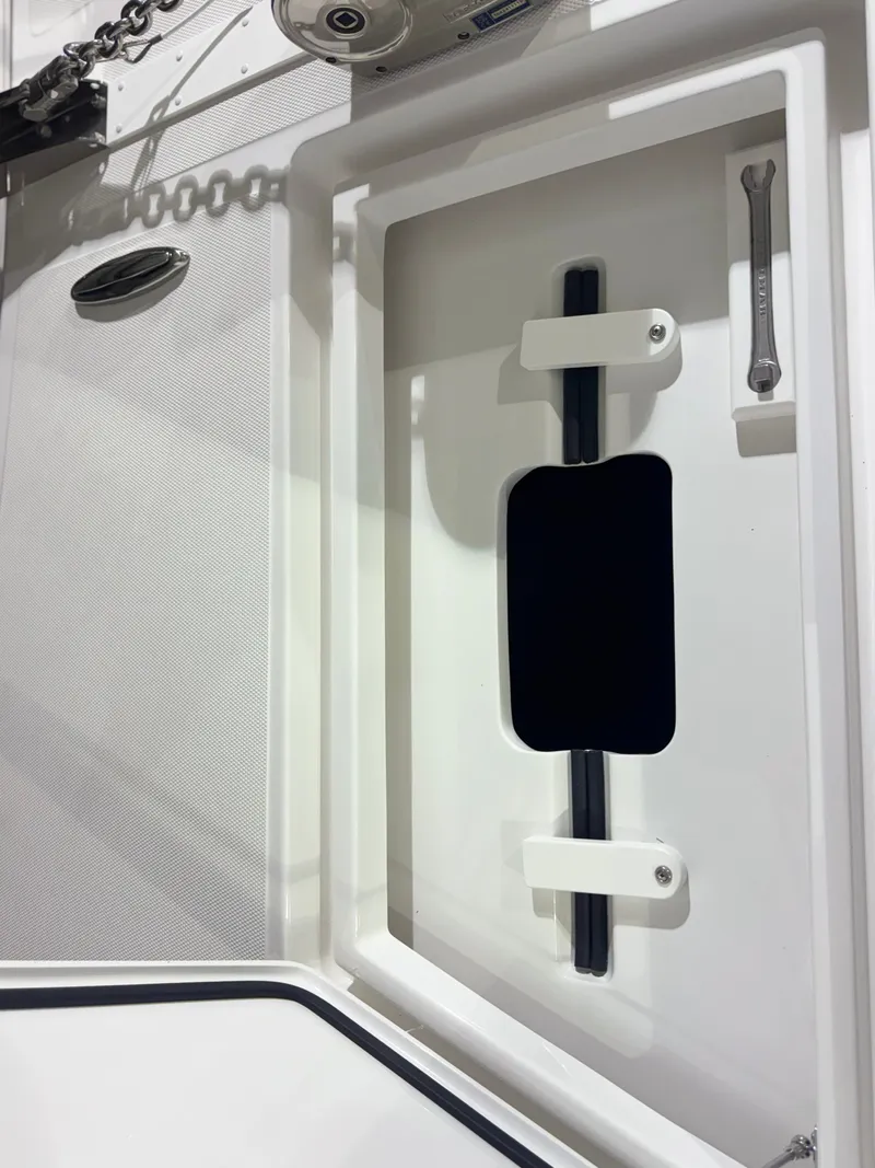 Slide: The Image of Close-up of a white boat deck with a black opening and a wrench. - 25