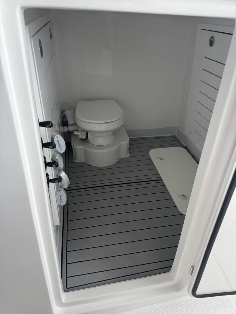 Slide: The Image of The image shows a clean, modern boat toilet with gray flooring and white walls. - 11