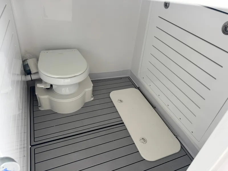 Slide: The Image of The image shows a clean, modern boat toilet with gray flooring and white walls. - 14