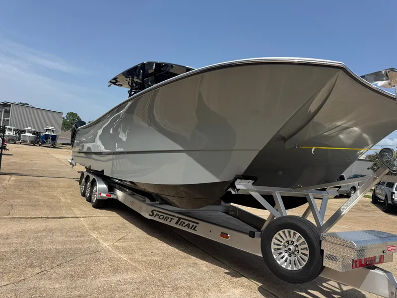 Slide: The Image of A gray boat, model 37 Cat by Front Runner Boatworks, sits on a trailer in a parking lot. - 5