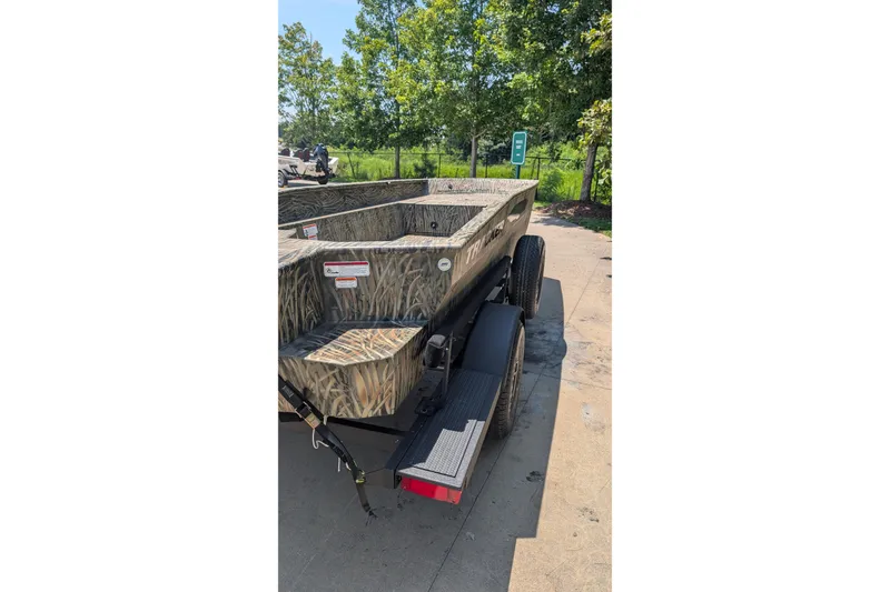 Slide: The Image of 2026 Tracker Grizzly 1650 T Prairie Wings Edition boat with camouflage design on trailer. - 13
