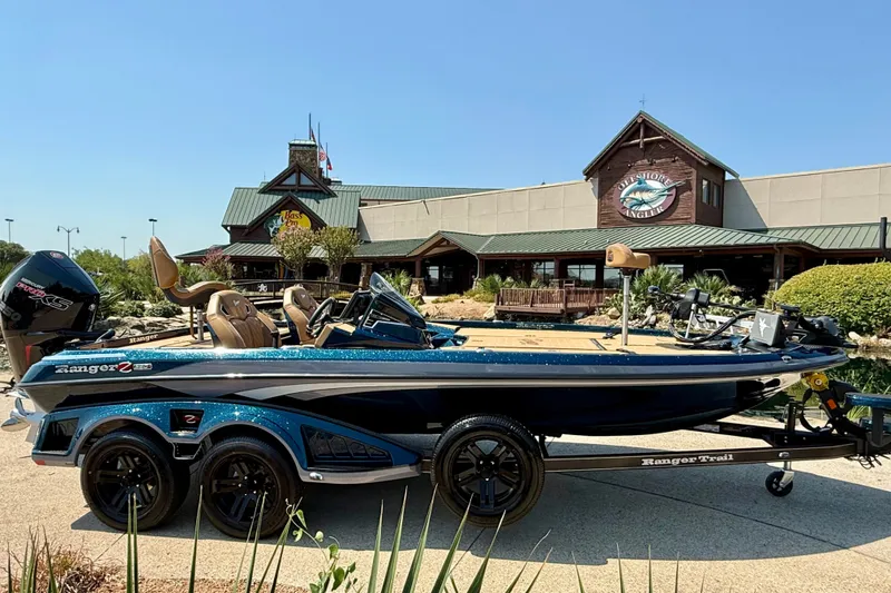 The Image of 2026 Ranger Z520R Ultra boat parked outside a rustic building on a sunny day. - 0