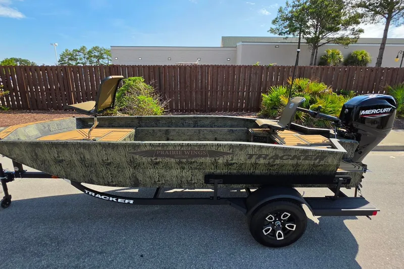 Slide: The Image of 2026 Tracker Grizzly 1650 T Prairie Wings Edition boat on trailer, outdoors. - 9