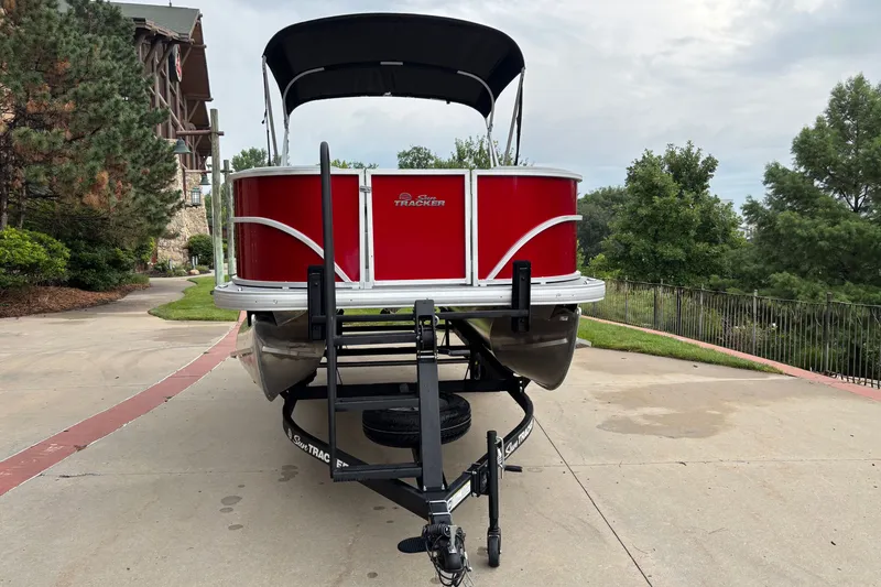 Slide: The Image of 2026 Sun Tracker Party Barge 18 DLX pontoon boat on trailer, parked outdoors. - 2