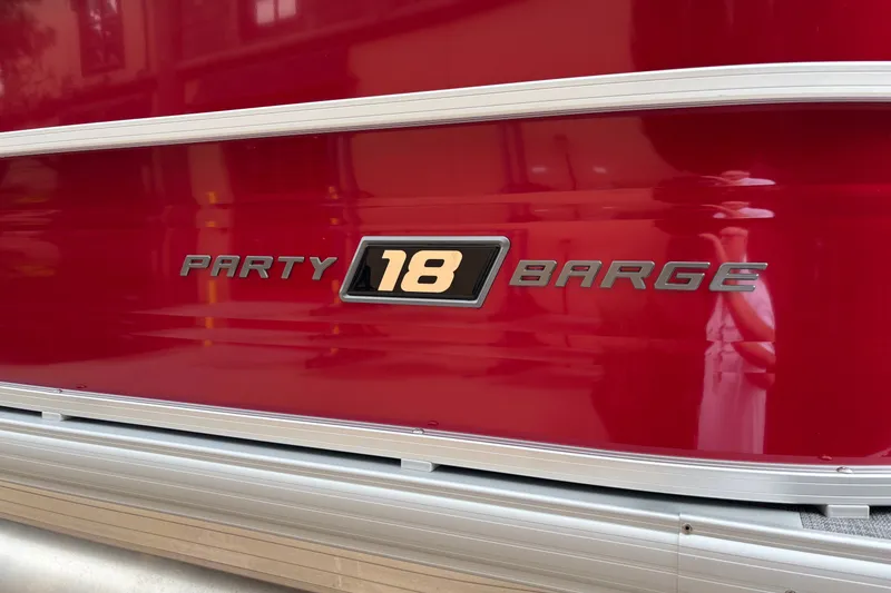 Slide: The Image of 2026 Sun Tracker Party Barge 18 DLX, red exterior with logo detail. - 9