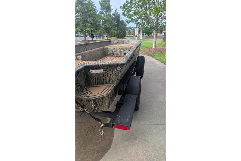 Slide: The Image of 2026 Tracker Grizzly 1650 T Prairie Wings Edition boat on trailer, camo design. - 13