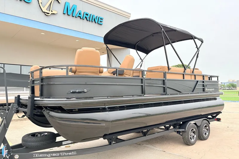 Slide: The Image of 2026 Ranger 223FC pontoon boat with canopy, displayed at a marine dealership. - 2
