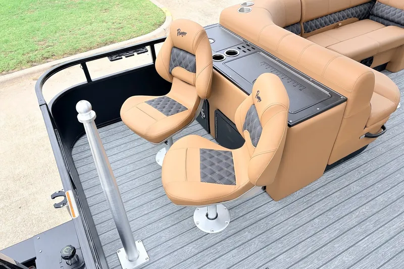 Slide: The Image of 2026 Ranger 223FC boat interior with tan and black seating, featuring cup holders and storage. - 37