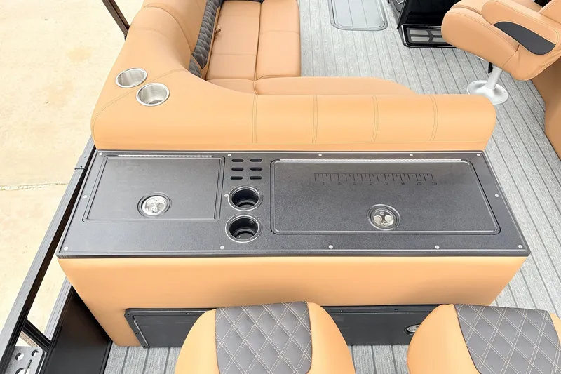 Slide: The Image of 2026 Ranger 223FC boat interior with tan seating, cup holders, and storage compartments. - 39