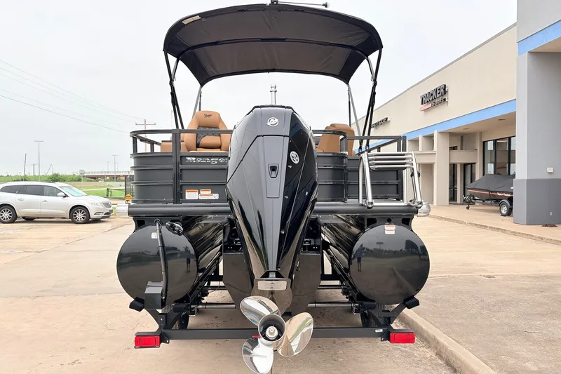Slide: The Image of 2026 Ranger 223FC pontoon boat with outboard motor, parked outside dealership. - 7
