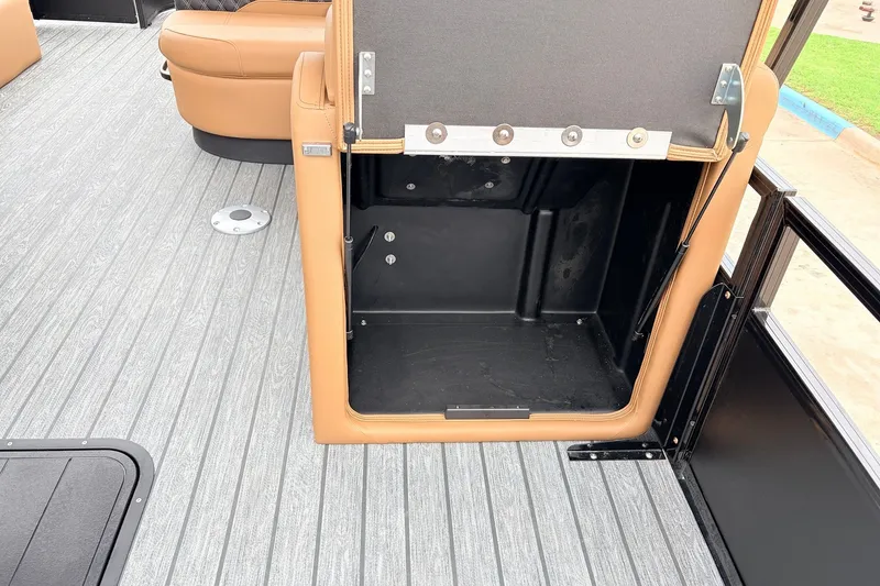 Slide: The Image of Open storage compartment on 2026 Ranger 223FC boat with gray flooring and tan seating. - 24