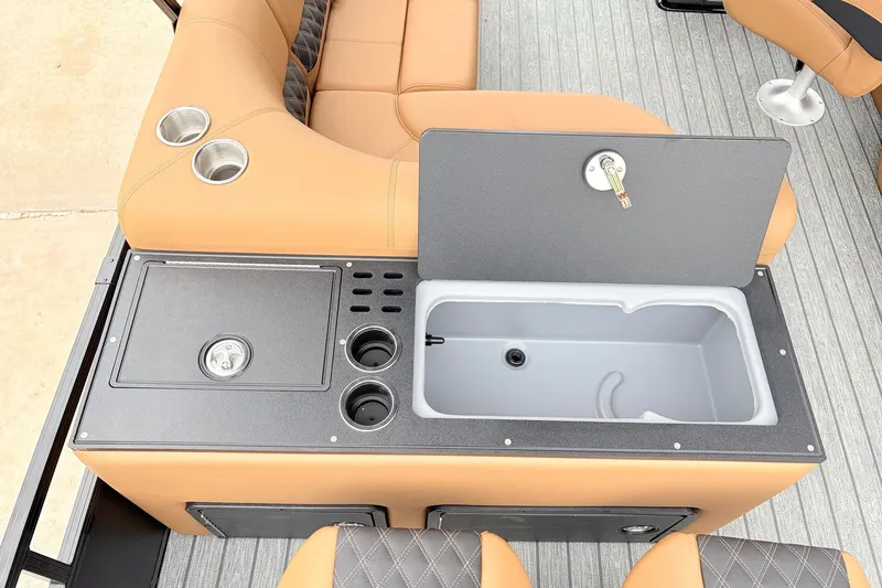 Slide: The Image of 2026 Ranger 223FC boat interior with tan seating, cup holders, and built-in storage compartment. - 41