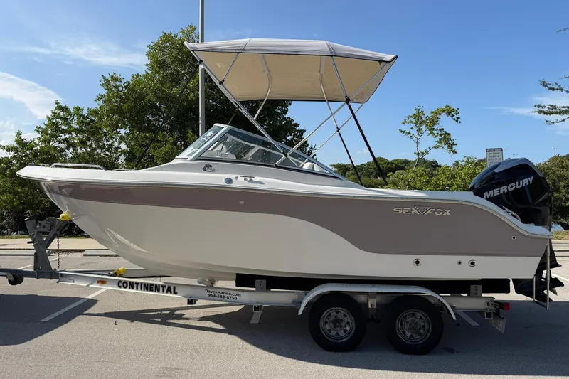 Slide: The Image of 2011 Sea Fox 216 Dual Console boat on trailer with Mercury engine, parked outdoors. - 6