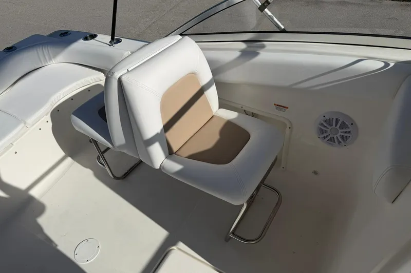 Slide: The Image of Interior seating of a 2011 Sea Fox 216 Dual Console boat, featuring white and beige upholstery. - 13
