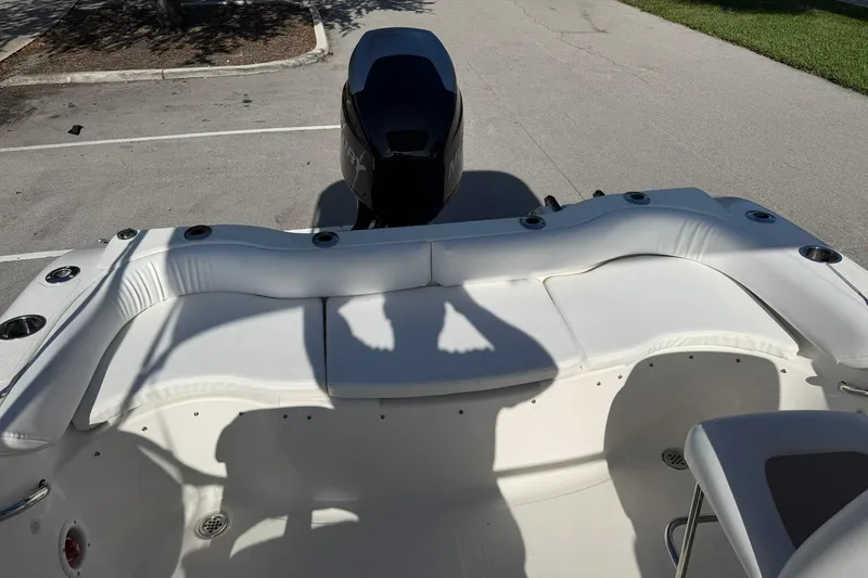 Slide: The Image of 2011 Sea Fox 216 Dual Console boat interior with seating and motor in parking lot. - 11