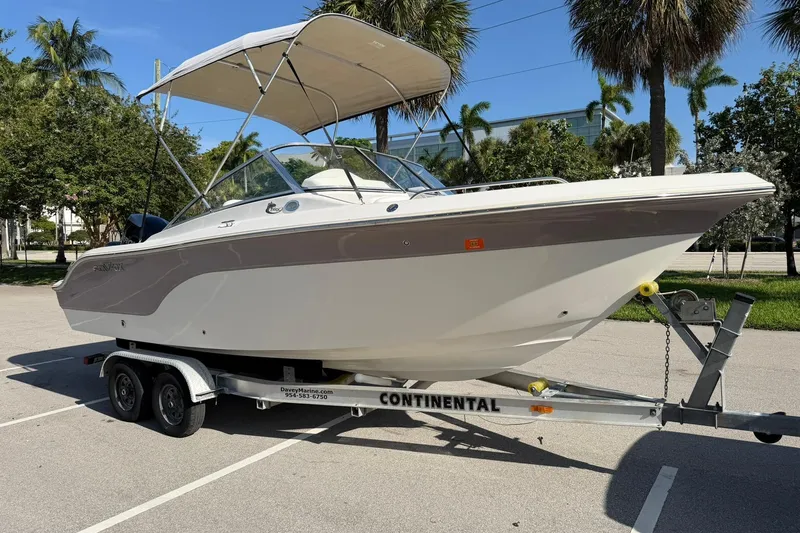 The Image of 2011 Sea Fox 216 Dual Console boat on trailer, parked under palm trees. - 1