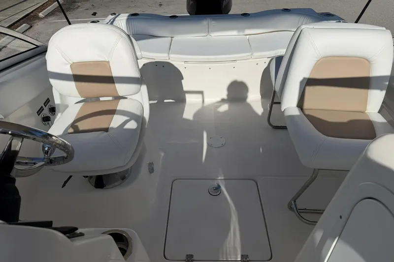 Slide: The Image of 2011 Sea Fox 216 Dual Console interior with white and beige seating, steering wheel, and deck. - 20