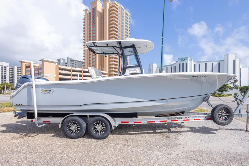 Slide: The Image of 2022 Sea Hunt Gamefish 27 boat on trailer, urban backdrop, clear sky. - 51